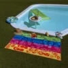 display de la toalla de playa chanclas sobre el cesped de la piscina