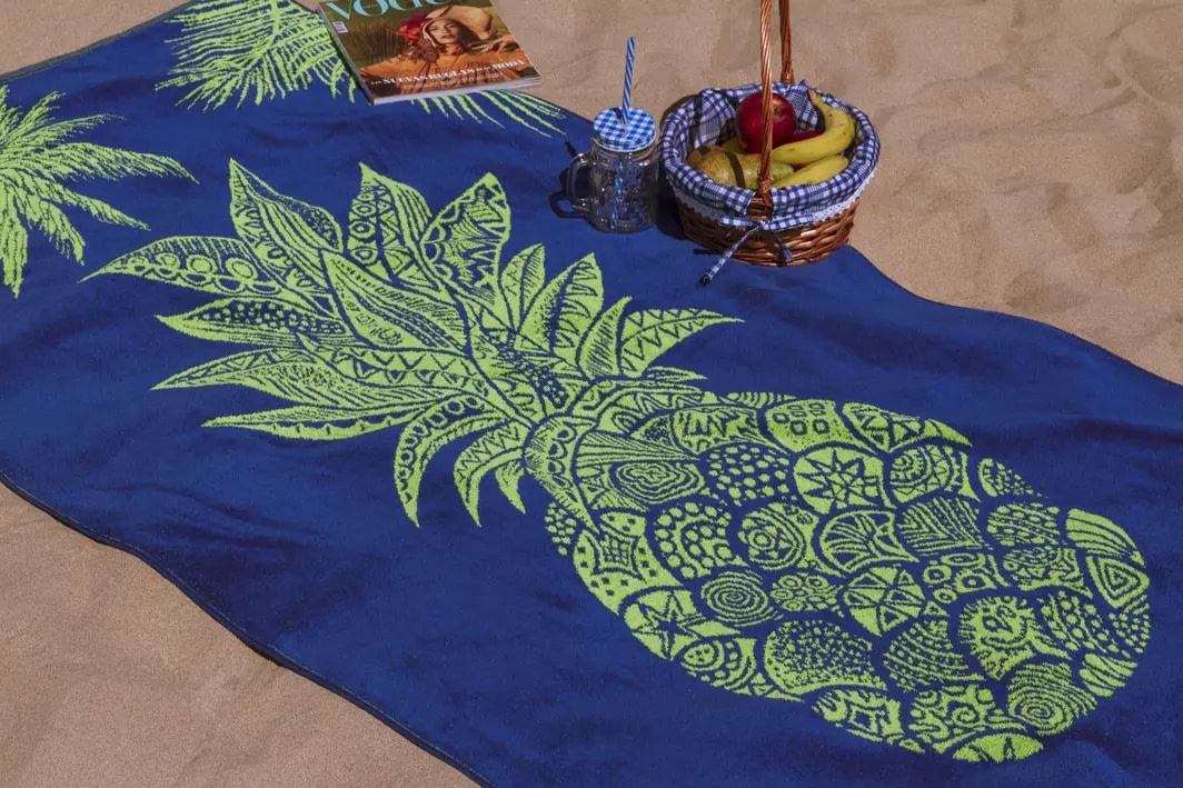 toalla de playa piña extendida en la arena de la playa