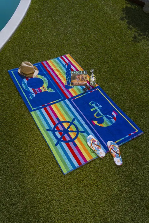 display de la toalla de playa popa sobre el cesped de la piscina